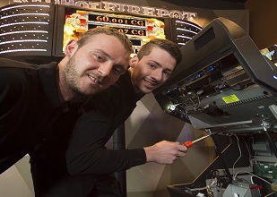 Automatenfachmann bei der Reparatur eines Automaten Automatenfachmann bei der Reparatur eines Automaten